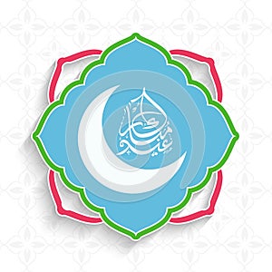Arabic Calligraphy Of Eid Mubarak With Crescent Moon On Islamic Frame And White Flower Pattern