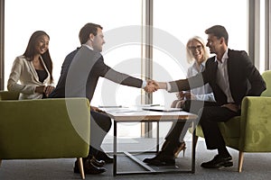 Arabic and caucasian male business partners handshaking at meeting