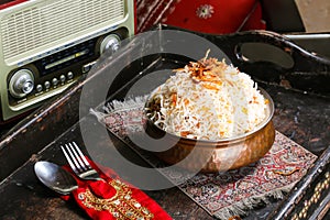 Arabic Chicken Biryani or Meat Biriyani with Fried Onion served in dish isolated on red mat top view on table arabic food