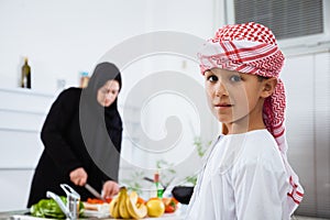 Arabic child in the kitchen with his mother