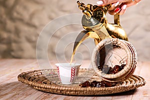 Arabic coffee with dates served with teapot in cup  on background top view ramadan food