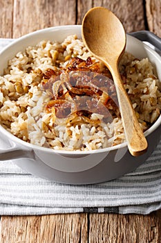 Arabic cuisine: rice with lentils and fried onions close-up in a