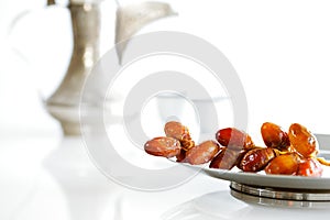 Arabic dates on a plate with Arabic coffee pot of the Bedouin