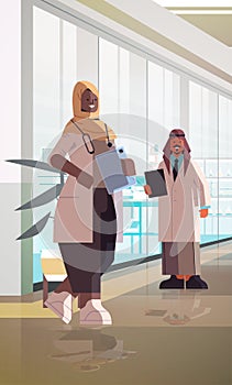 Arabic doctors couple in uniform standing together man woman medical professionals discussing during meeting
