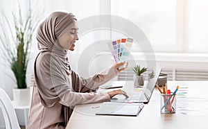 Arabic Graphic Designer Working With Color Swatches And Laptop In Office