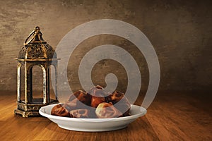 Arabic lantern and bowl of fresh dried dates on wooden floor, Ramadan kareem backgrounds