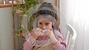 Arabic Little Girl Eating Sandwich Having Lunch Sitting In Kitchen