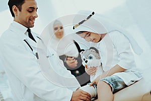 Arabic Male Doctor Bandaging Limb of Child Patient