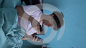 Arabic man using mobile banking holding smartphone and credit card in bed at home. Online shopping application concept.