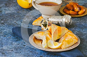 Arabic and middle eastern food concept. Fatayer sabanekh - traditional arabic spinach triangle hand pies on a blue stone