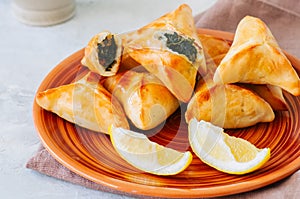 Arabic and middle eastern food concept. Fatayer sabanekh - traditional arabic spinach triangle hand pies dates and tea on a white