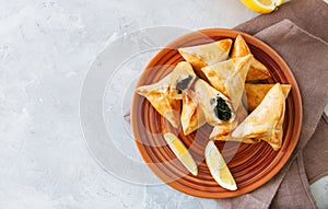 Arabic and middle eastern food concept. Fatayer sabanekh - traditional arabic spinach triangle hand pies on a white stone