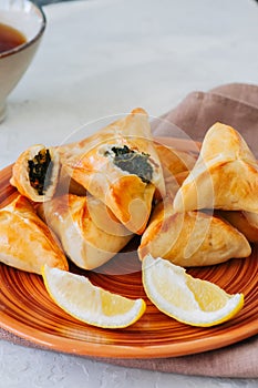 Arabic and middle eastern food concept. Fatayer sabanekh - traditional arabic spinach triangle hand pies on a white stone