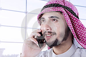 Arabic person talking on cellphone in airport