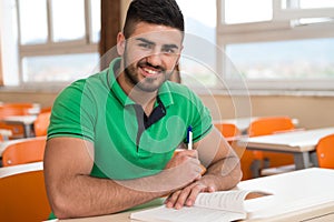 Arabic Student With Books Sitting In Classroom