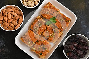 Arabic sweet Basbousa, Hareeseh, or Nammoura, almonds, pistachios and Medjool dates
