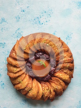 Arabic sweets. Arabian Qatayef pancake stuffed with sweet cheese and nuts on the blue table