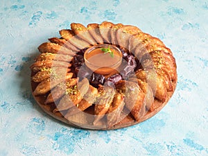 Arabic sweets. Arabian Qatayef pancake stuffed with sweet cheese and nuts on the blue table