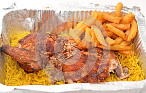 Arabic Syrian cuisine of grilled barbecued chicken with yellow Basmati rice and french fries, fried potatoes fingers served in a