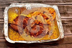 Arabic Syrian cuisine of grilled barbecued chicken with yellow Basmati rice and french fries, fried potatoes fingers served in a