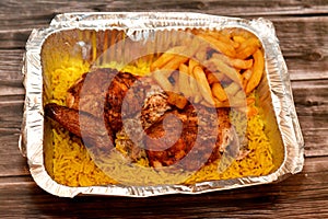 Arabic Syrian cuisine of grilled barbecued chicken with yellow Basmati rice and french fries, fried potatoes fingers served in a