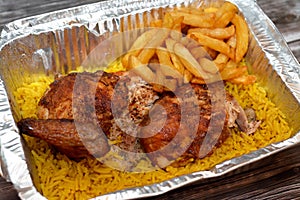 Arabic Syrian cuisine of grilled barbecued chicken with yellow Basmati rice and french fries, fried potatoes fingers served in a