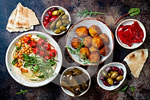 Arabic traditional cuisine. Middle Eastern meze with pita, olives, hummus, stuffed dolma, falafel balls, pickles.