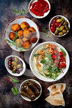 Arabic traditional cuisine. Middle Eastern meze with pita, olives, hummus, stuffed dolma, falafel balls, pickles. photo