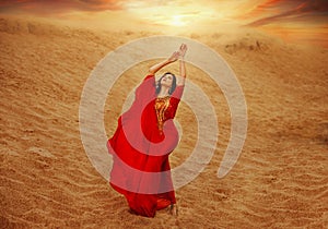 arabic woman in red long dress stands in desert long train silk fabric fly flutter in wind motion clothes gold beauty