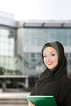 Arabic woman traditional dressed, in front of the building