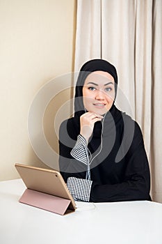 Arabic woman using tablet pc computer. Southeast Asian student at home. Muslim teenage girl living lifestyle.