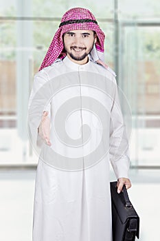 Arabic worker offers handshake in office