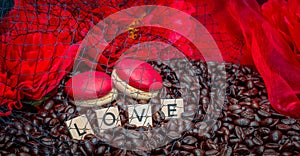 Red macaroon on rosted coffee beans  sexy background with red flowers and letters LOVE photo