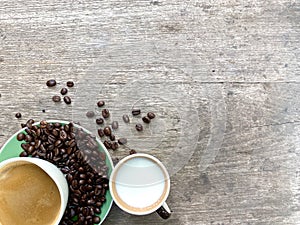 Arabica coffee beans in a cup of beverage and around the cup And with leaves on top are placed on a wooden table.