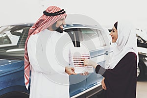 Arabs stand in a car shop and choose a color.