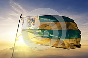 Aracaju city of Brazil flag textile cloth fabric waving on the top sunrise mist fog