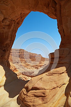 Arava desert landscape through an erosive stone window in a rock, Israel