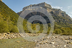Arazas mountain river with huge rock walls and forest in the background. Ordesa Valley photo