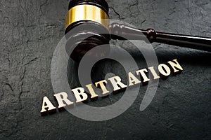 Arbitration word from wooden letters and gavel in court.