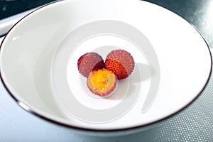 two ripe fruits in the saucer and one cut into slices photo