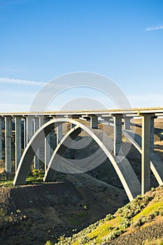 Arc concrete bridge a cross the river when sunset