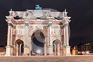 Arc de Triomphe on the Carrousel square near the Louvre museum at night, illuminated by lights and lanterns