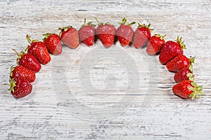 An arc of fresh ripe red strawberries