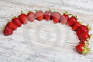 An arc of fresh ripe red strawberries