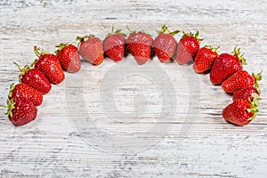 An arc of fresh ripe red strawberries lies