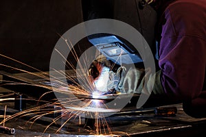 An arc welder welding two pieces of metal together