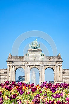 The arcade du Cinquantenaire on a sunny day  in Brussels, Belgium, with flowers in the foreground