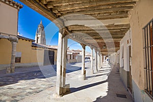 Medieval arcaded street and church tower in Ampudia old town photo