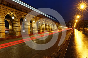 The arcades of Bercy bridge at rainy night, Paris.