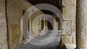 Arcades of very old houses with stone columns and wooden roofs in Pedraza, Segovia.